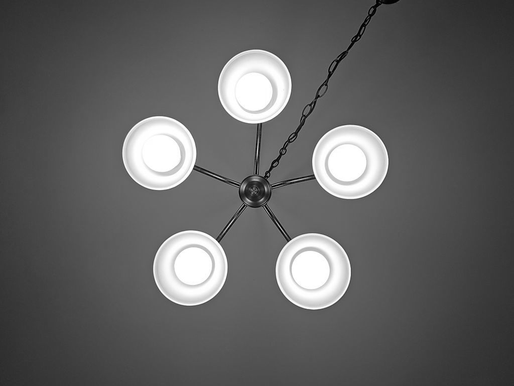 Bottom-up view of the dining room chandelier, muted in shades of black and piercing white that looked over me as I begrudgingly completed my homework.